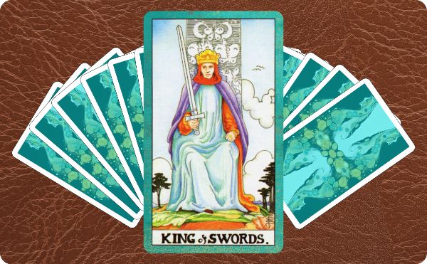 Rider Waite depiction of the King of Swords tarot card on top of a spread of other cards.