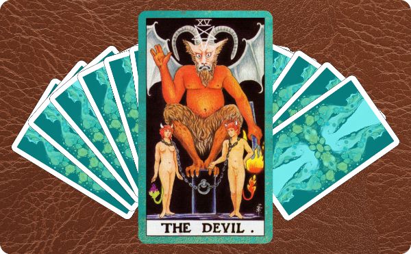 Rider Waite depiction of The Devil tarot card sitting on top of a spread of several other cards