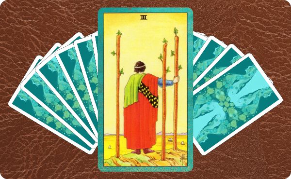 Rider Waite depiction of the Three of Wands tarot card sitting on top of a spread of other cards.