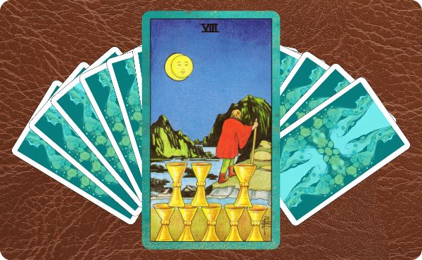 Rider Waite depiction of Eight of Cups tarot card sitting on top of a spread of other cards.