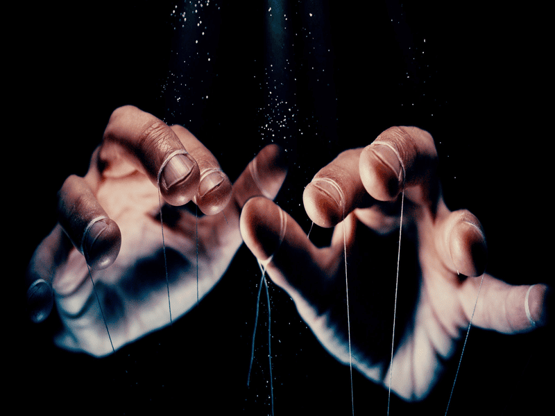 Hands with puppet strings controlling.