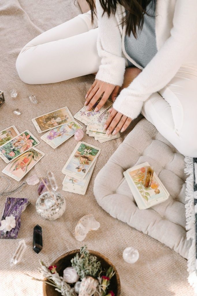 Woman sitting on floor with tarot cards spread in front of her